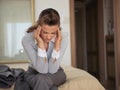 Stressed business woman sitting on bed in hotel Royalty Free Stock Photo