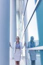 Stressed business woman standing next to the wall of an office building Royalty Free Stock Photo