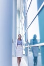 Stressed business woman standing next to the wall of an office building Royalty Free Stock Photo