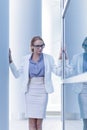 Stressed business woman standing next to the wall of an office building Royalty Free Stock Photo