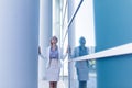 Stressed business woman standing next to the wall of an office building Royalty Free Stock Photo