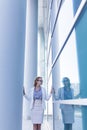 Stressed business woman standing next to the wall of an office building Royalty Free Stock Photo