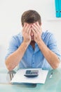 Stressed businessman covering his face at his desk Royalty Free Stock Photo