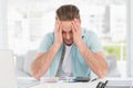 Stressed businessman covering his face at his desk Royalty Free Stock Photo