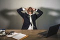 Stressed businessman feeling depressed and overwhelmed working at office computer desk tired and exhausted defeated by business f Royalty Free Stock Photo