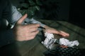 Businessman Crumpling Papers In Office. Stressed businessman with hands, sitting at workplace with crumbled papers on black shadow