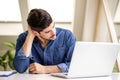 Stressed businessman having pain in his neck while working on laptop Royalty Free Stock Photo