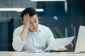 Stressed businessman holding face with his hands because having trouble. Bankrupt Asian Male is sitting with laptop Royalty Free Stock Photo