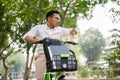 A stressed businessman is in a hurry to get to work, riding a bike, checking time on his wristwatch Royalty Free Stock Photo