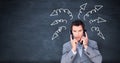 Stressed businessman on phones with arrow doodles on blackboard Royalty Free Stock Photo