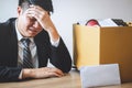 Stressed businessman receive fired letter from company and packing belongings and files into brown cardboard box, changing and Royalty Free Stock Photo