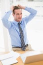 Stressed businessman sitting at his desk Royalty Free Stock Photo
