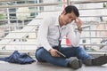 Stressed businessman worry financial bankruptcy. Depressed asian male sitting on the street tired after failed to rescue company