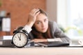 Stressed businesswoman missing deadlines in office