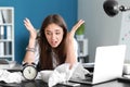 Stressed businesswoman missing deadlines in office