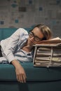 Stressed businesswoman sleeping on a couch with lots of paperwork Royalty Free Stock Photo