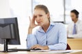 Stressed Businesswoman Working At Desk In Busy Office Royalty Free Stock Photo