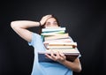 Stressed college student carrying a stack of books Royalty Free Stock Photo