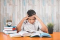 Stressed college student learning hard with books in exams preparation feeling overwhelmed, depressed and exhausted Royalty Free Stock Photo