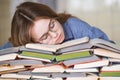 Stressed college student tired of hard learning with books in exams tests preparation Royalty Free Stock Photo