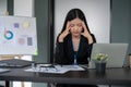 A stressed Asian businesswoman working on her financial project at her desk, thinking pensively Royalty Free Stock Photo