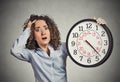Stressed corporate employee holding clock looking anxiously running out of time Royalty Free Stock Photo