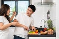 Stressed couple conflict in their kitchen, angry woman pointing hand to man for preparing vegetables healthy food Royalty Free Stock Photo