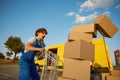 Stressed courier screaming looking at falling parcel boxes from trolley cart