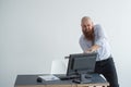 Stressed crazy businessman smashing his computer in office using ax problem concept. The man has problems at work and Royalty Free Stock Photo