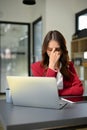 Stressed and depressed Asian businesswoman sits at her office desk, suffering from eyes strain Royalty Free Stock Photo