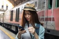 Stressed depressed young Asian backpacker looking phone and feeling shock and frustrated after miss a train. Problem and travel Royalty Free Stock Photo