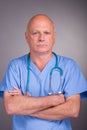 Stressed doctor with arms folded, wearing surgical mask and stethoscope. Royalty Free Stock Photo