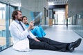 Stressed doctor and nurse sitting on floor examining X-ray report Royalty Free Stock Photo