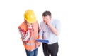 Stressed engineer and upset builder checking clipboard