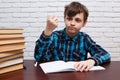 Stressed and exhausted pupil with torn papers sitting at the des Royalty Free Stock Photo