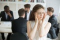 Stressed female corporate employee having migraine during briefi