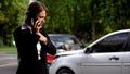 Stressed female driver talking phone car collision scene, auto damage, insurance Royalty Free Stock Photo