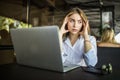 Stressed female student having headache touching temples preparing for test in cafe. Frustrated millennial girl feels nervous or t Royalty Free Stock Photo