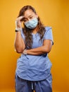 Stressed filipina nurse wearing scrubs and PPE