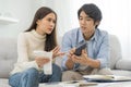 Stressed financial owe asian young couple love hand in holding bills, sitting on sofa together, stressed and confused by calculate Royalty Free Stock Photo