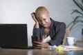 Stressed and frustrated afro American black woman working upset at office laptop computer desk gesturing angry looking at mobile p