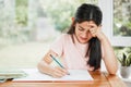 Stressed, frustrated and unhappy girl writing homework with a difficult task alone at home. Tired school child studying Royalty Free Stock Photo