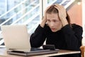 Stressed frustrated young businessman puts his head in hand thinks about job. Exhausted employee staff feels disappointed and Royalty Free Stock Photo