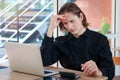 Stressed frustrated young businessman putting his head in his hand thinking about his job, feeling disappointed or tired camera Royalty Free Stock Photo