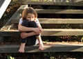 Stressed girl on wooden stairs Royalty Free Stock Photo