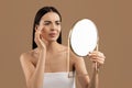 Stressed half-naked woman looking at mirror and touching her face Royalty Free Stock Photo