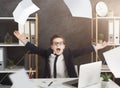 Stressed little boy in suit throwing papers in air