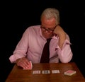 Stressed looking elderly man playing poker