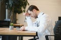 Stressed male doctor sat at his desk. Mid adult male doctor working long hours. Overworked doctor in his office. Not Royalty Free Stock Photo