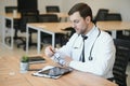 Stressed male doctor sat at his desk. Mid adult male doctor working long hours. Overworked doctor in his office. Not Royalty Free Stock Photo